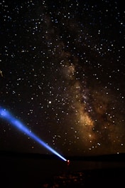 A vibrant night sky filled with stars and a telescope pointing upwards.