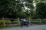 Close-up of a vintage motorcycle parked beside a rustic wooden cabin in the Norwegian countryside.