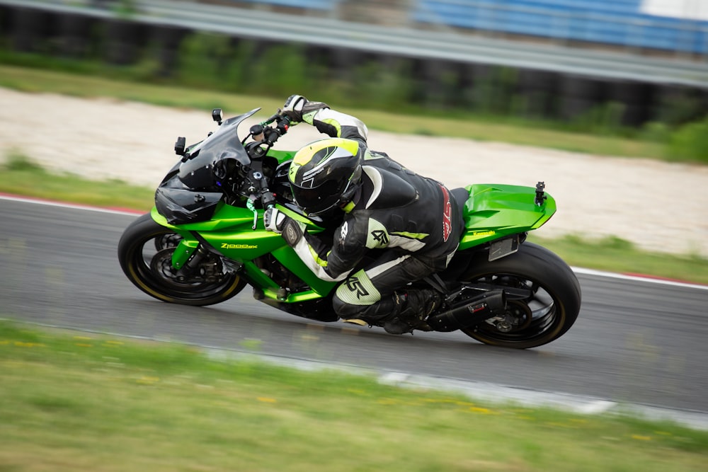 man in green and black motorcycle suit riding on green sports bike