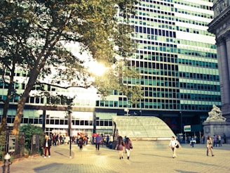 A bustling urban public facility with people entering and exiting under bright daylight.