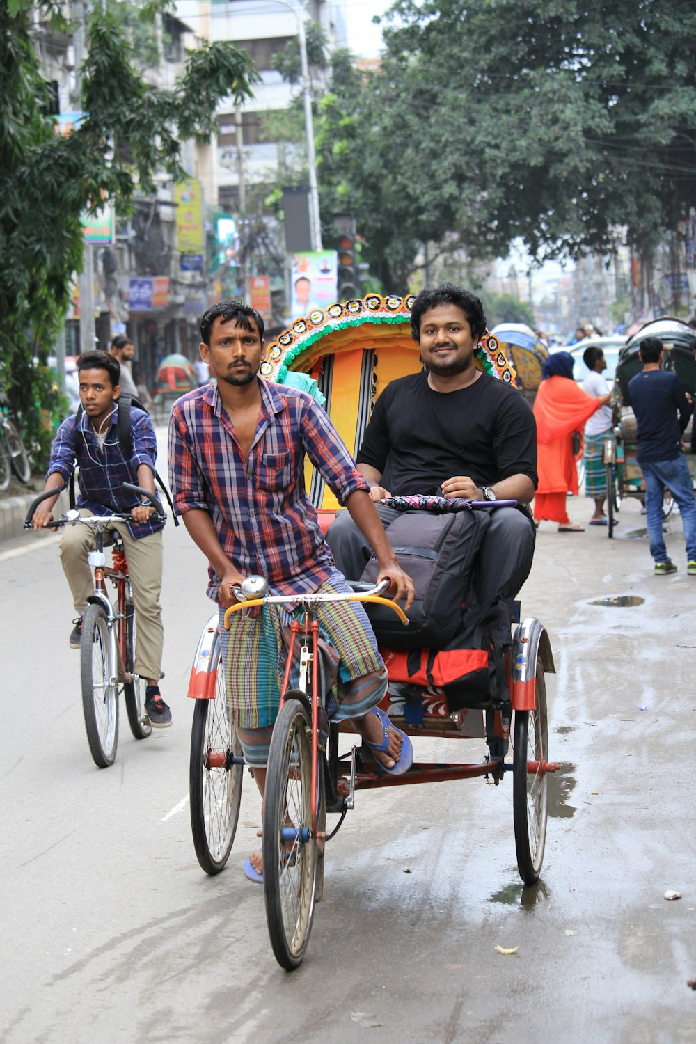 man and woman riding on red and yellow trike