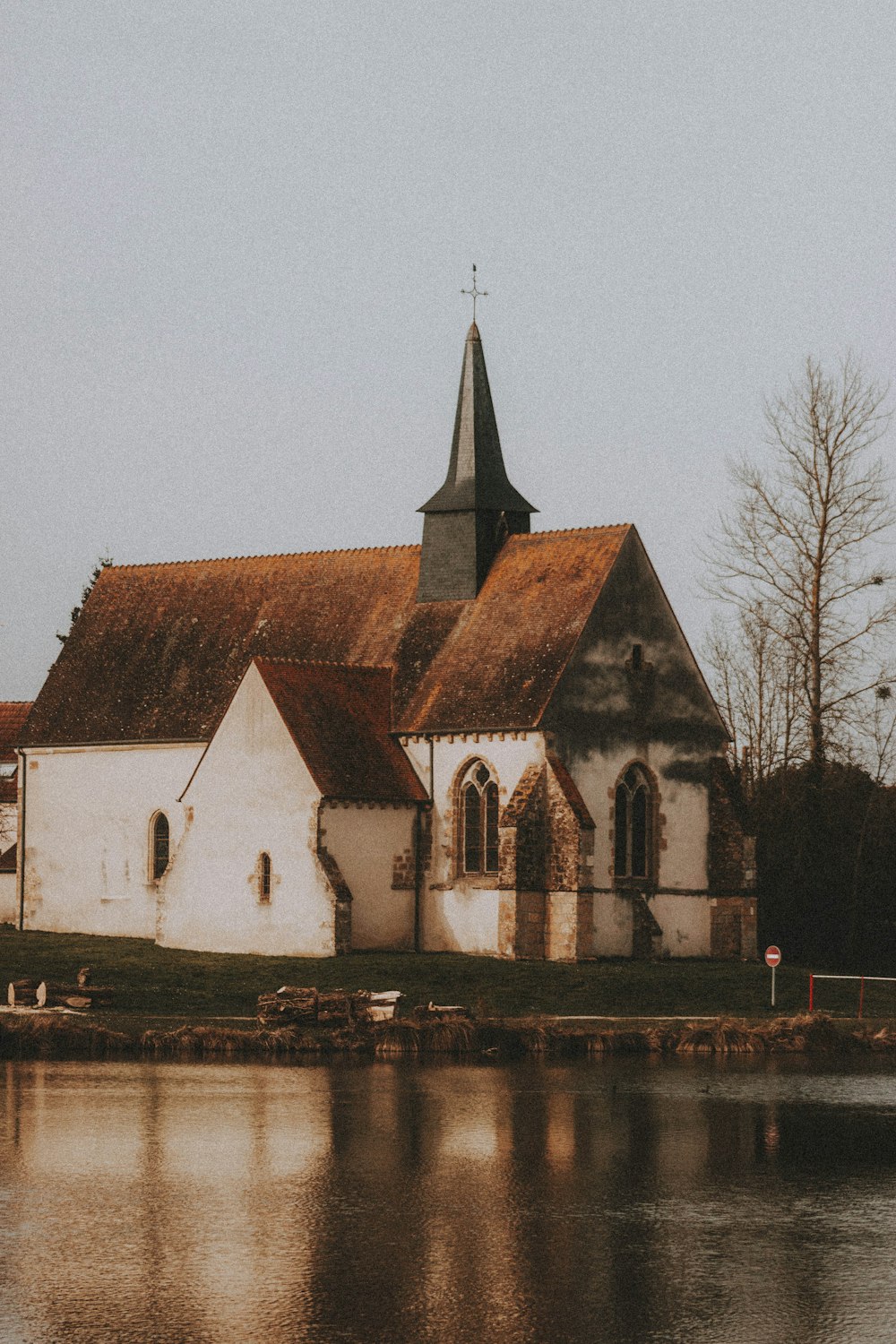 brown and white concrete church near bare trees during daytime