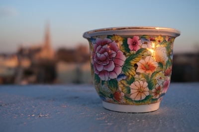 Close-up of a hand-painted ceramic cup featuring delicate floral patterns in soft pastels.