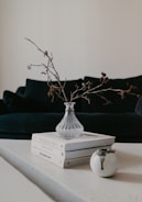 Modern side table with a vase and books on top in a minimalist setting