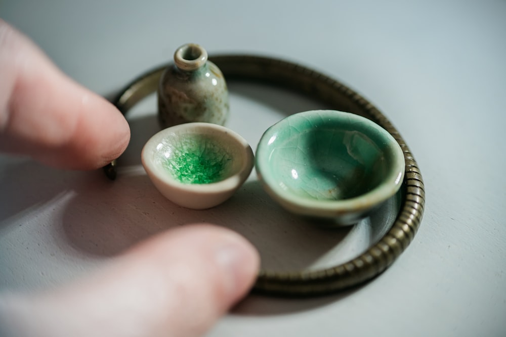 Persona sosteniendo un anillo de plata y piedra verde azulado