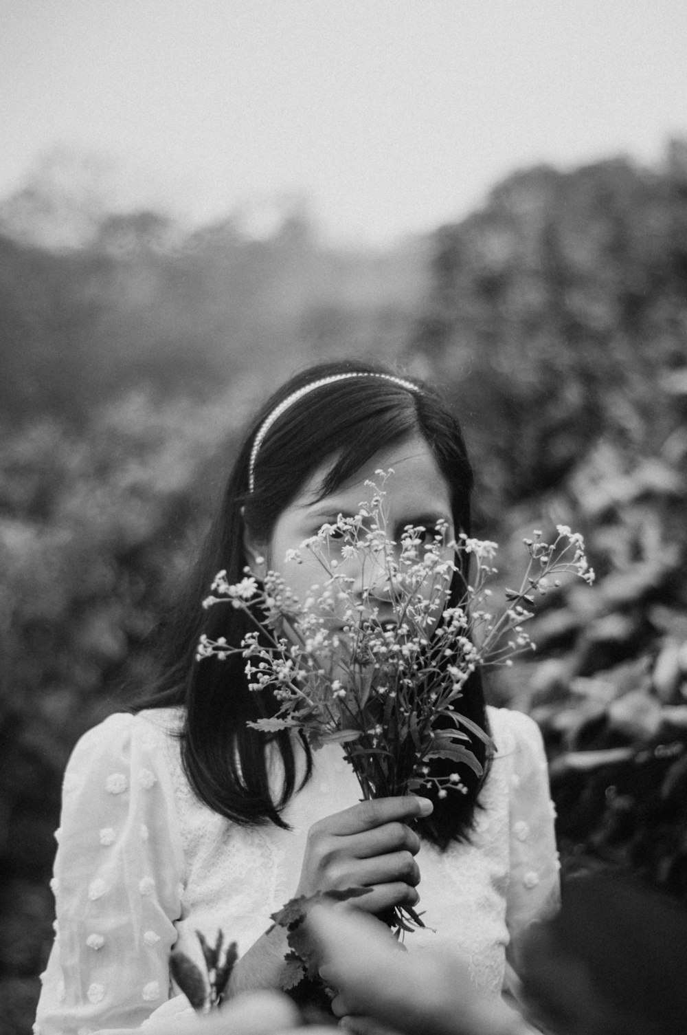 grayscale photo of woman holding flowers