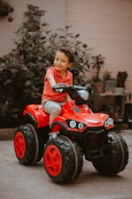 boy in red long sleeve shirt riding red and black atv
