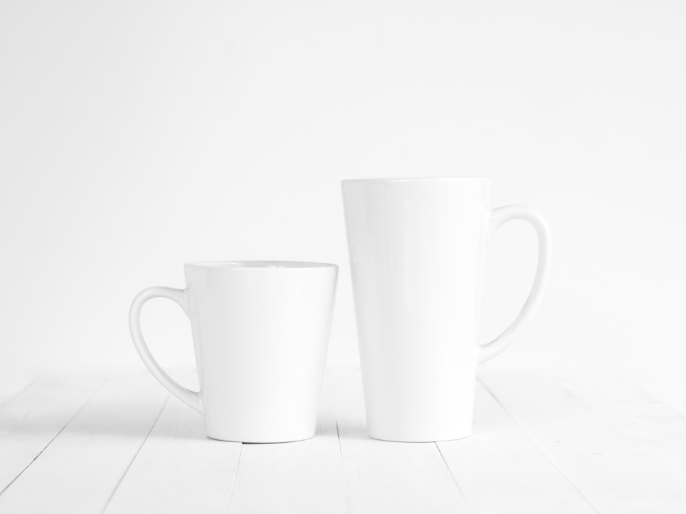2 tazas de cerámica blanca sobre mesa blanca