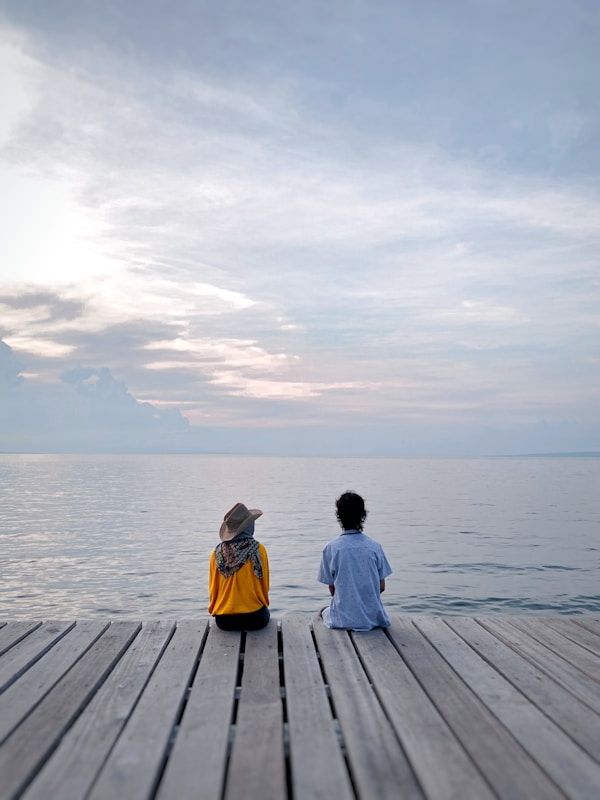 Couple Sits Near The Seaby Nadhil Ramandha