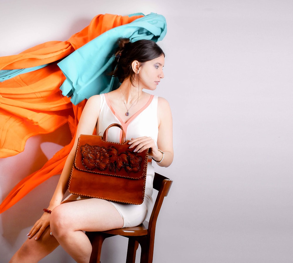 woman in white tank top sitting on white wooden chair