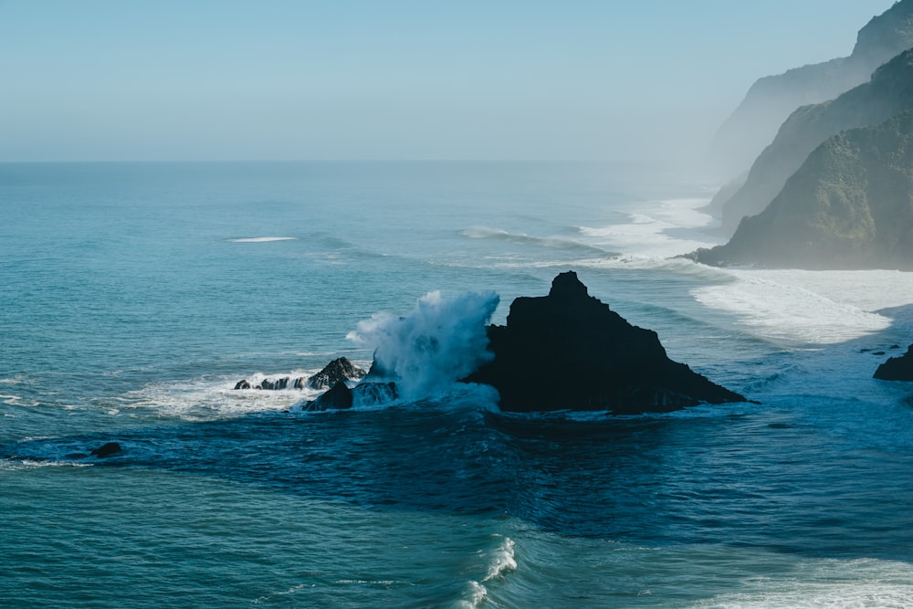 a large wave crashing into the shore of a beach