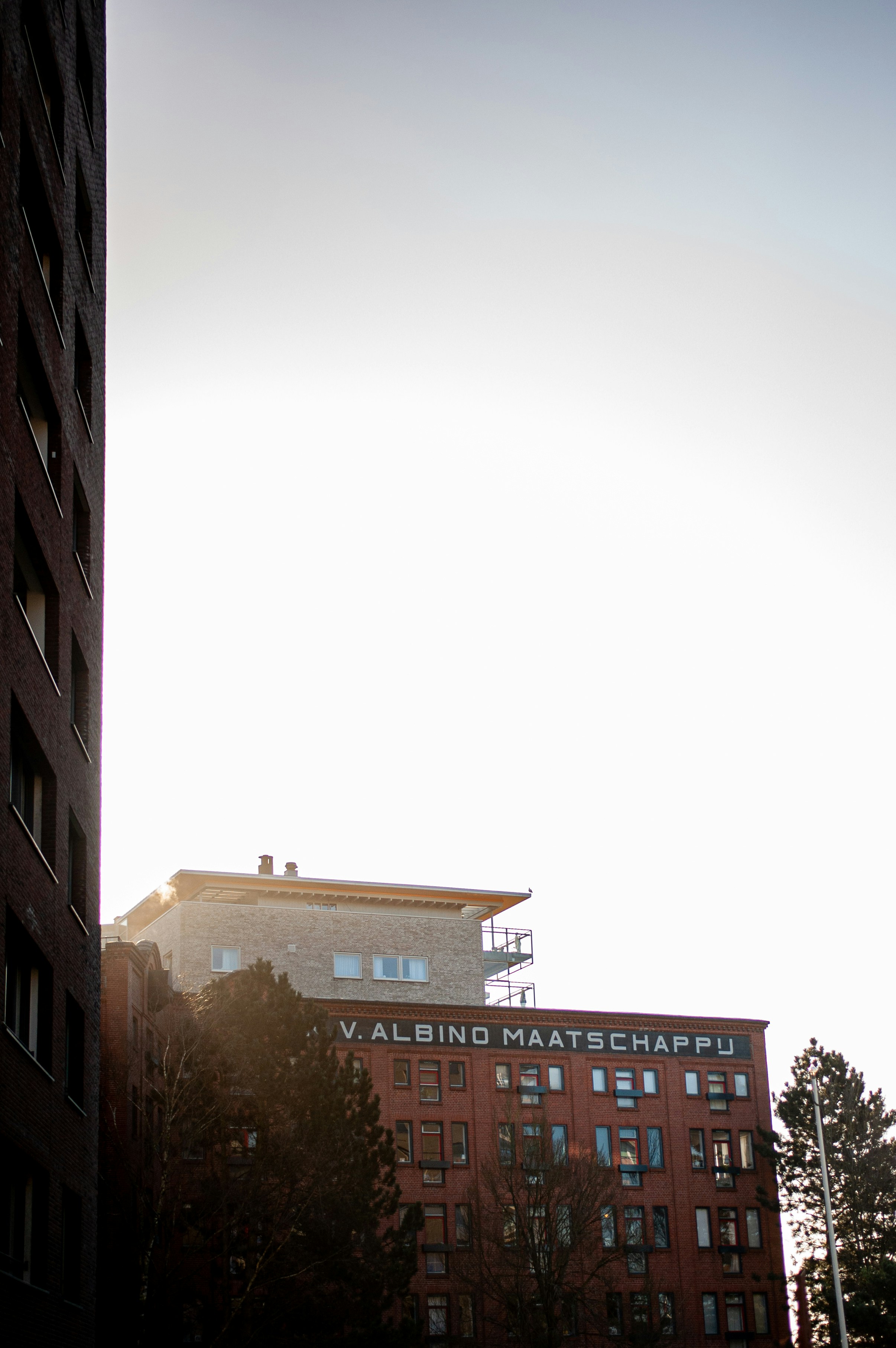 Edificio de hormigón marrón bajo el cielo blanco durante el día