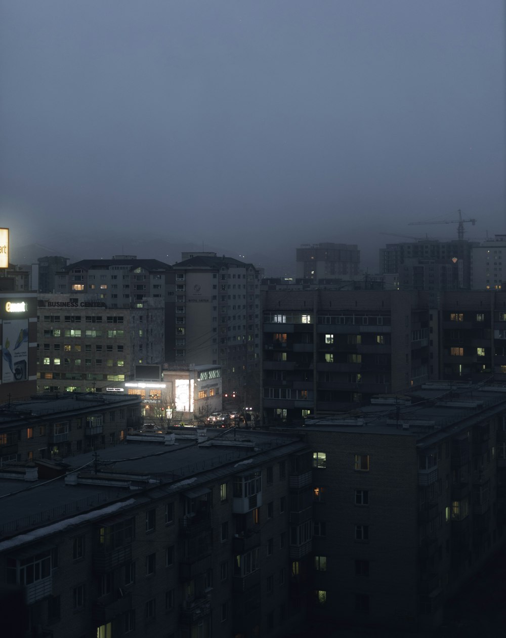 city buildings under gray sky during night time