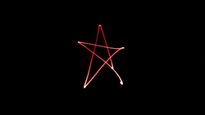 Magical night scene with a glowing pentagram drawn on the floor surrounded by candles