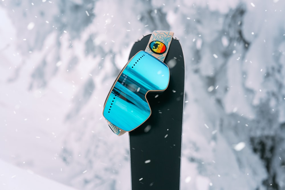 blue and black surfboard on snow covered ground