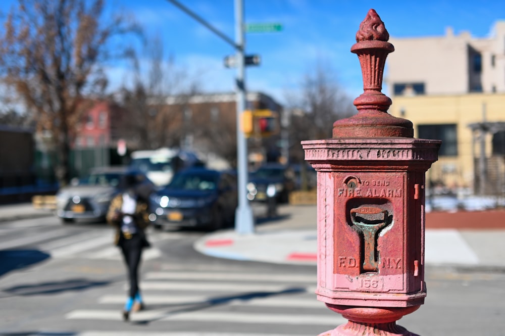 red and brown fire hydrant on sidewalk during daytime