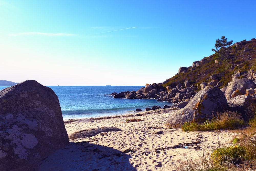 black rock formation on sea shore during daytime