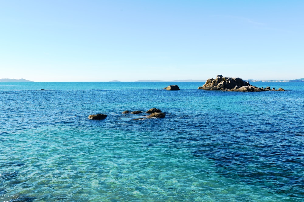 costa rocosa bajo el cielo azul durante el día