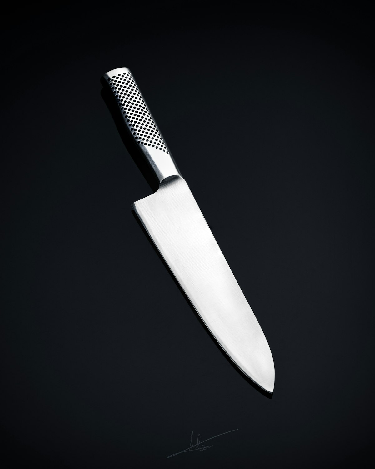 Black-handled chef knife on a wooden board