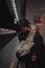 woman in black coat covering her face with gray scarf