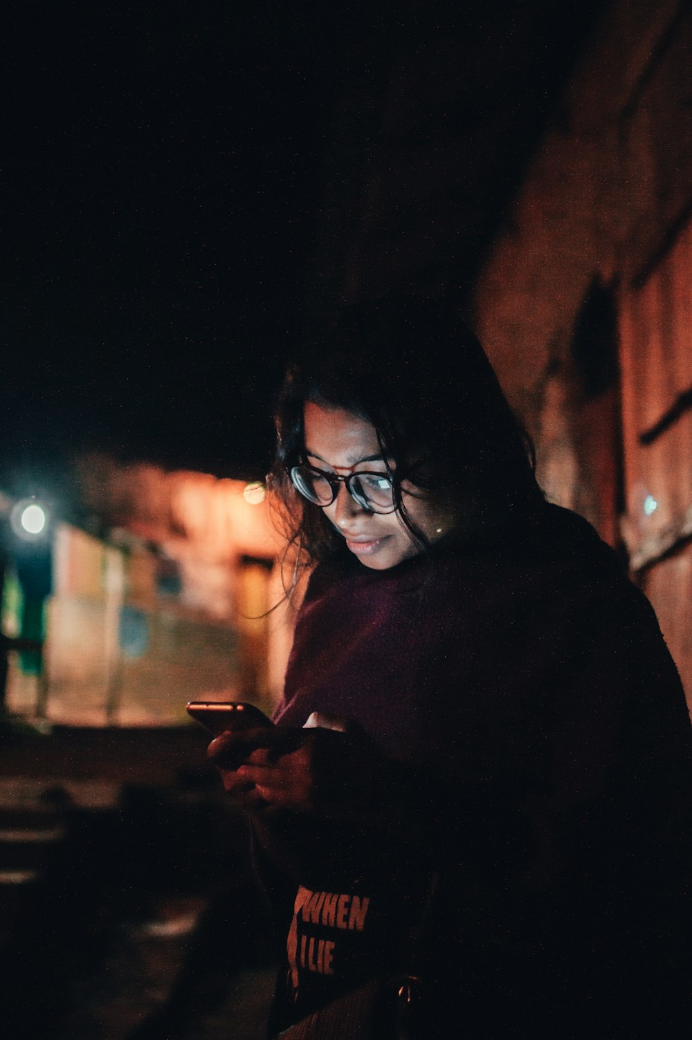 woman in black framed eyeglasses holding smartphone