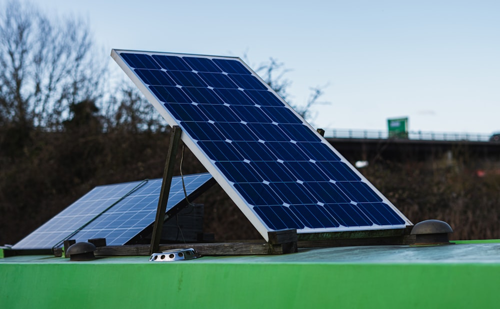 blau-weißes Solarpanel auf grüner Metallstange tagsüber