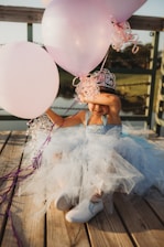 woman in white and pink floral dress holding balloons