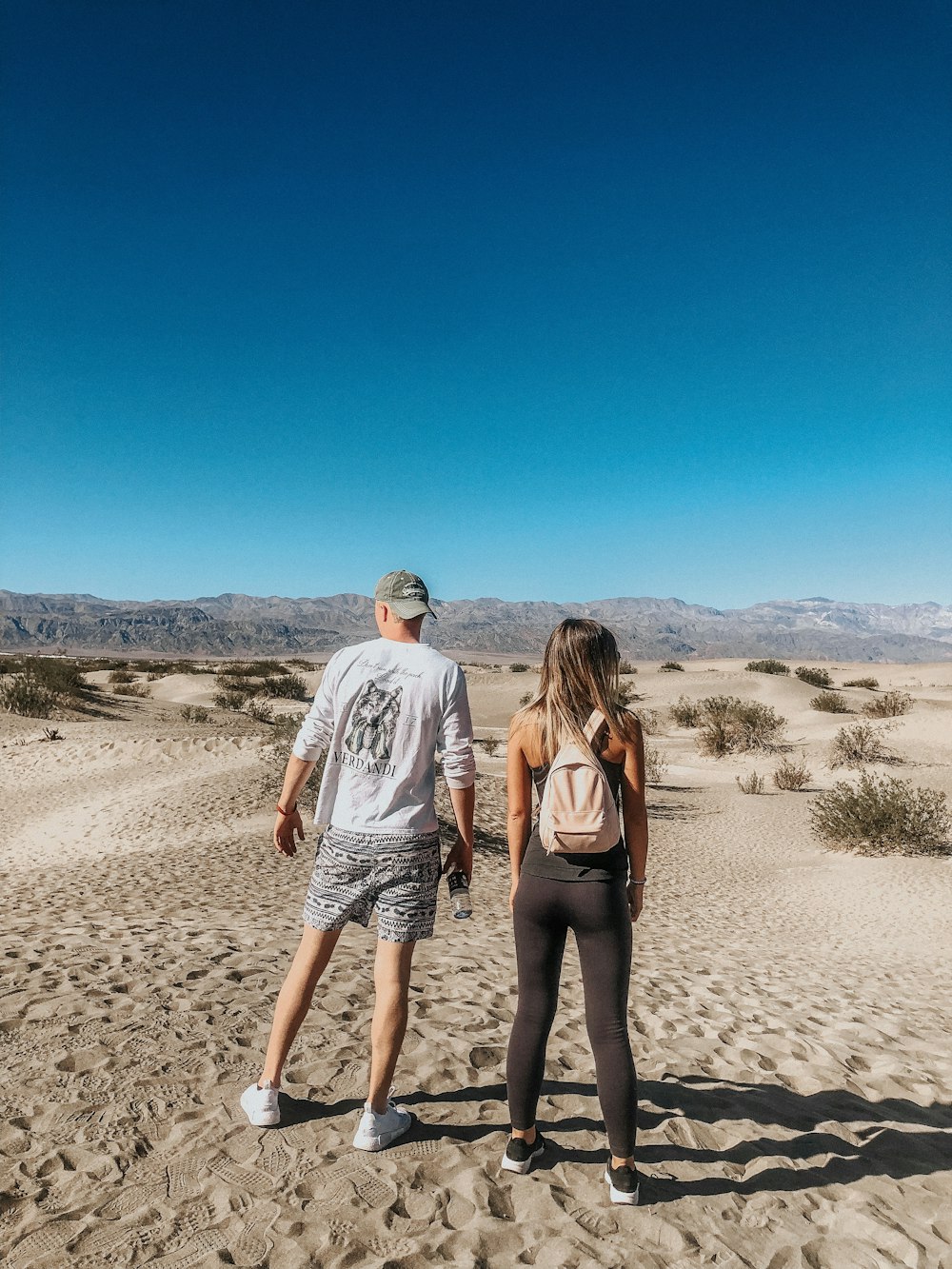 couple walking on brown sand during daytime