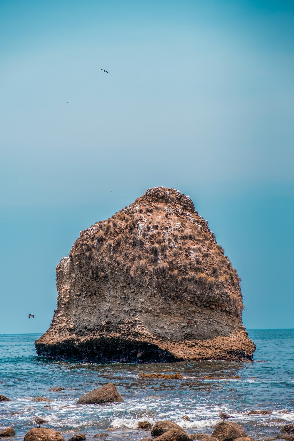 brown rock formation on sea during daytime