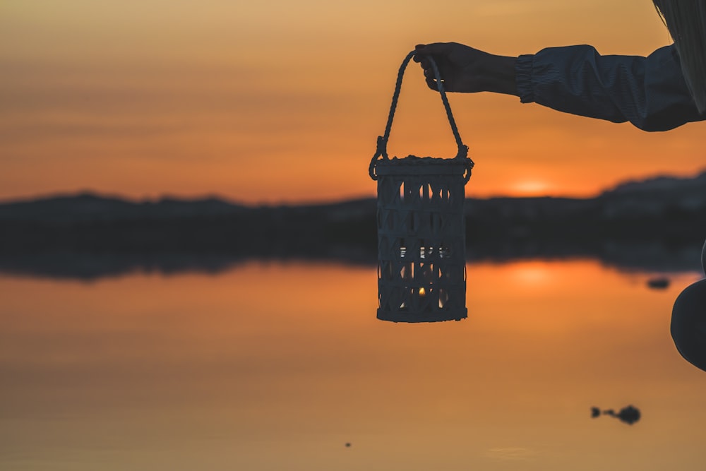 silhouette of person holding basket during sunset