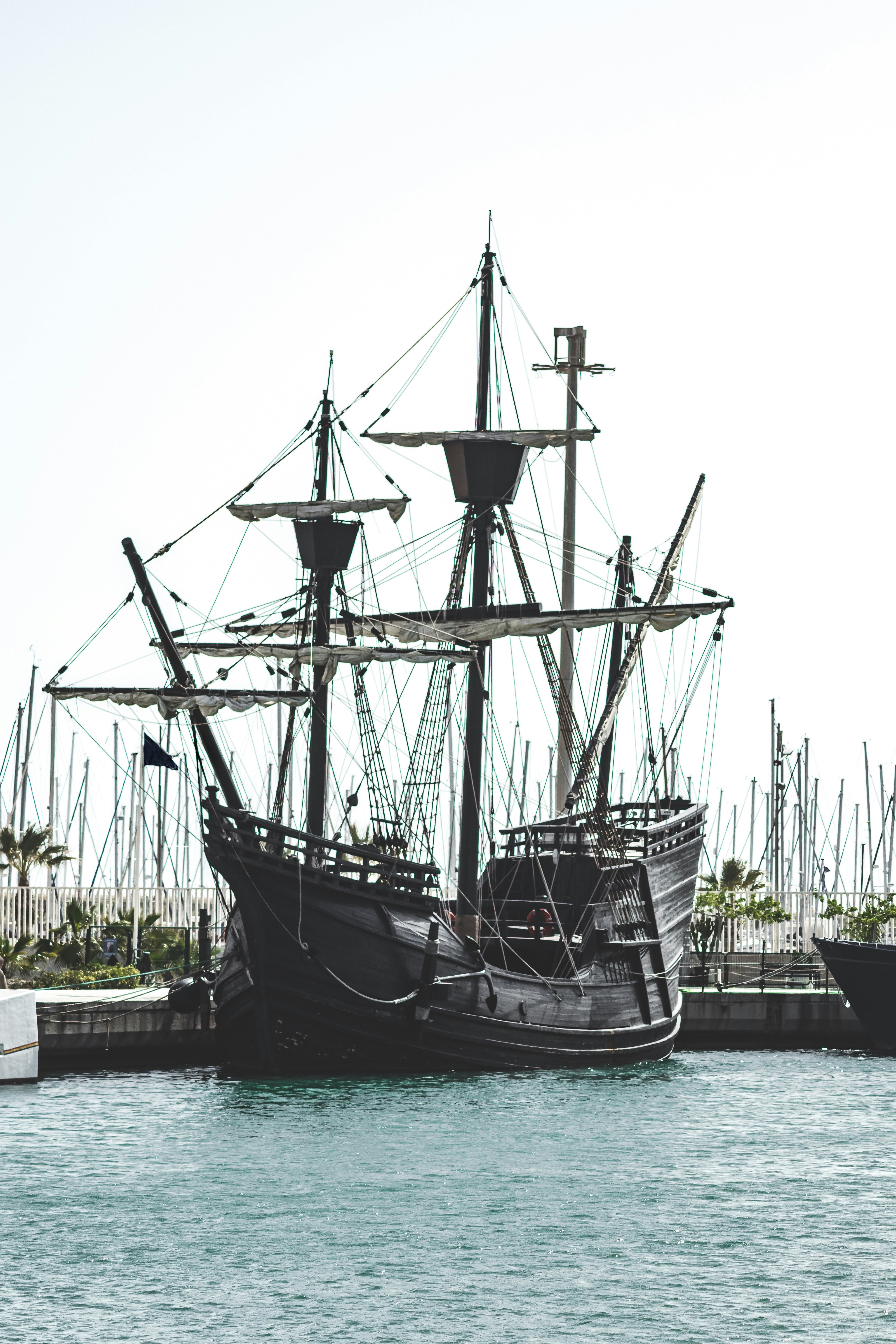 black and white sail ship on dock during daytime