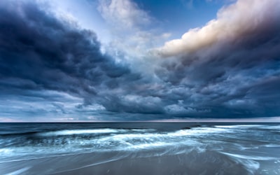 ocean waves under cloudy sky during daytime stormy teams background