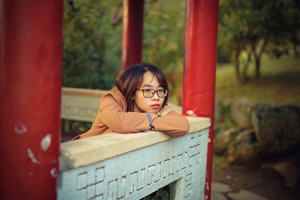 woman in brown long sleeve shirt wearing black framed eyeglasses