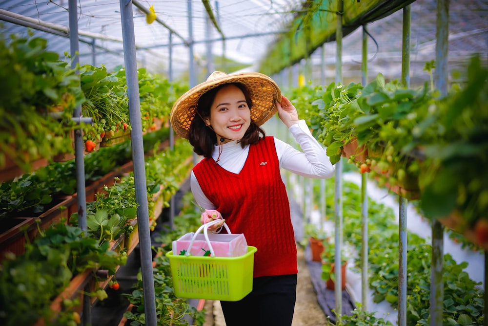 woman in red and white long sleeve shirt holding green basket