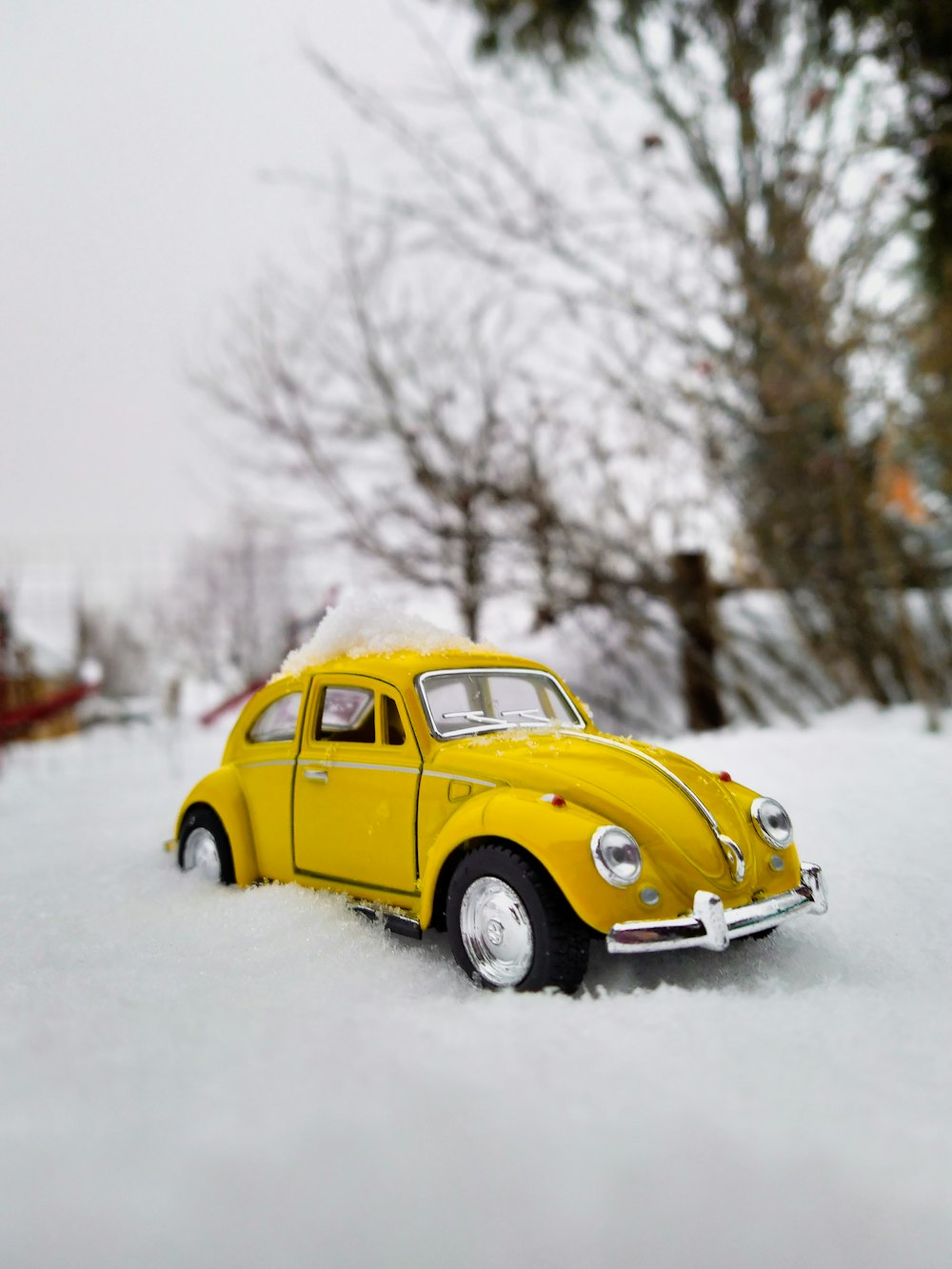 yellow volkswagen beetle on snow covered ground during daytime
