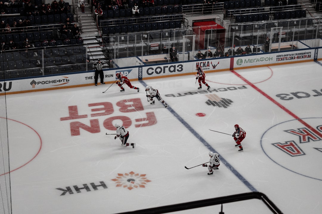 man in white and red hockey jersey riding on white and red hockey table