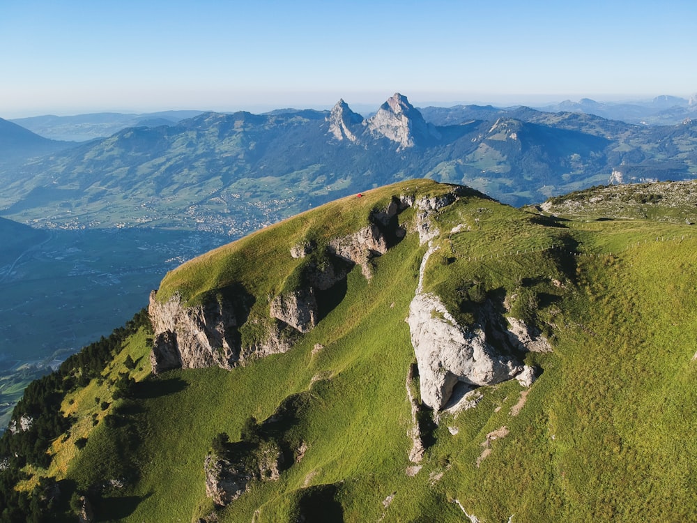 green mountain beside blue sea under blue sky during daytime