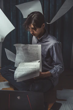 Close-up of a student reviewing scholarship application documents at a desk.