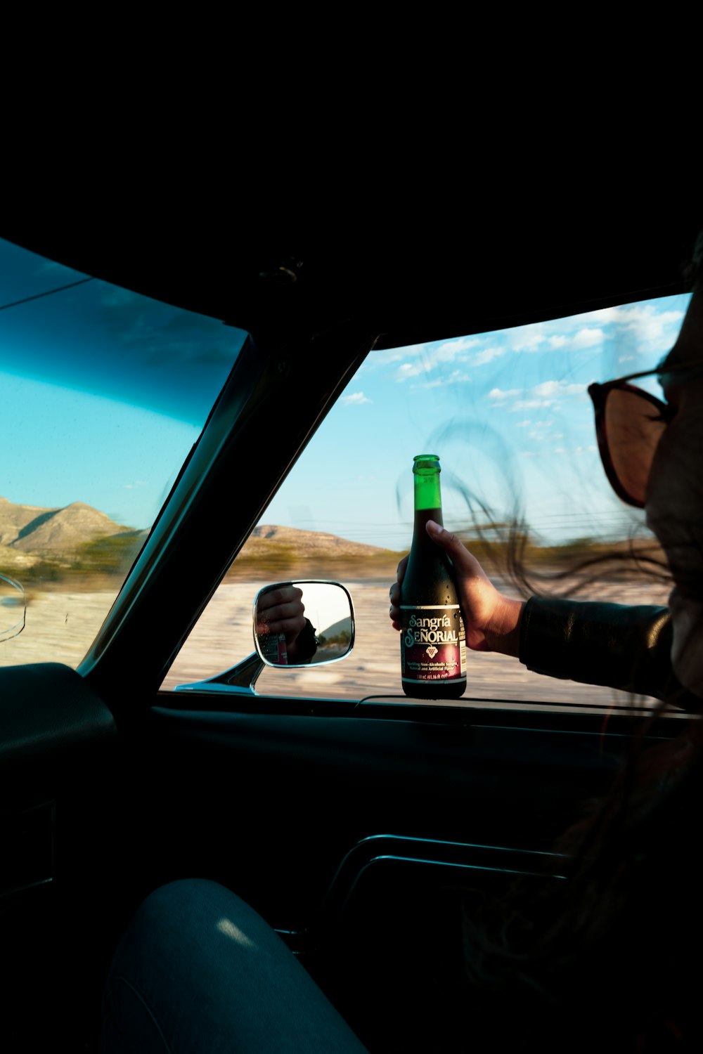 man in black sunglasses holding beer bottle