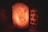 A beautifully lit Himalayan salt lamp glowing softly in a cozy room.