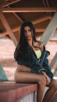 Ziya Model escort woman in black and yellow dress sitting on brown wooden bench during daytime