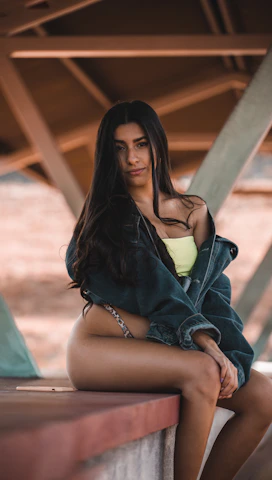 Ziya Model escort woman in black and yellow dress sitting on brown wooden bench during daytime