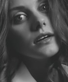 Close-up black and white portrait highlighting expressive eyes and subtle emotions.