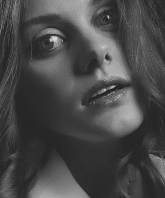 Close-up black and white portrait highlighting expressive eyes and subtle emotions.