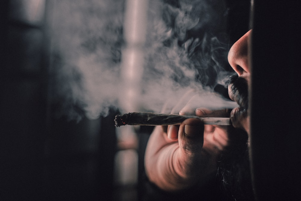 man smoking cigarette in close up photography