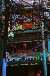 a restaurant with neon signs on the front of it