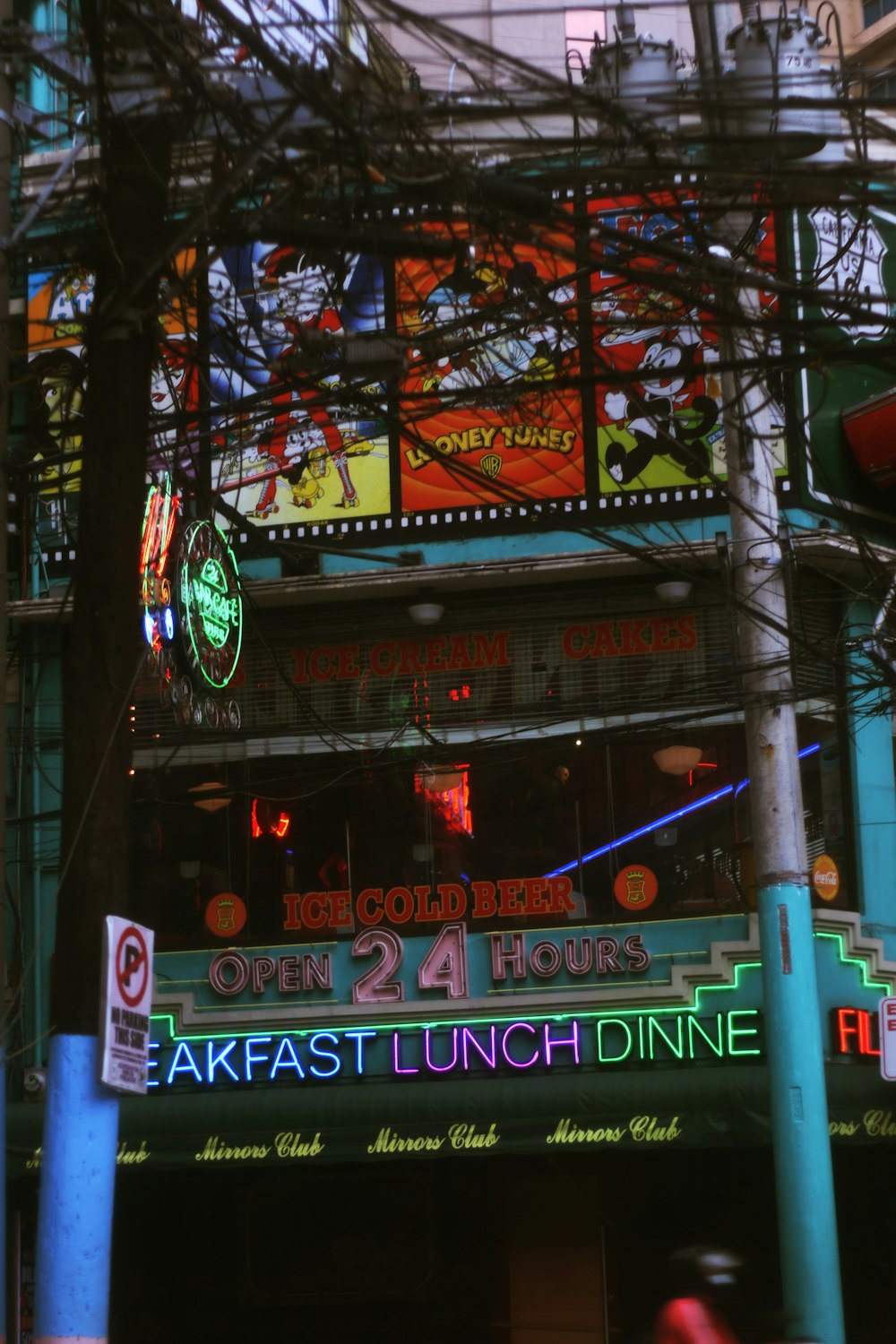 a restaurant with neon signs on the front of it