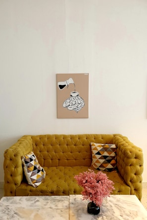 A vibrant mustard yellow sofa with tufted backrest, perfect for a lively space.