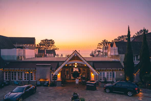 Luxurious villa exterior at dusk with warm beige lighting.