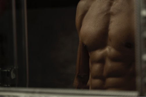 A close-up of a bodybuilder’s hands and muscles during a precise pose.